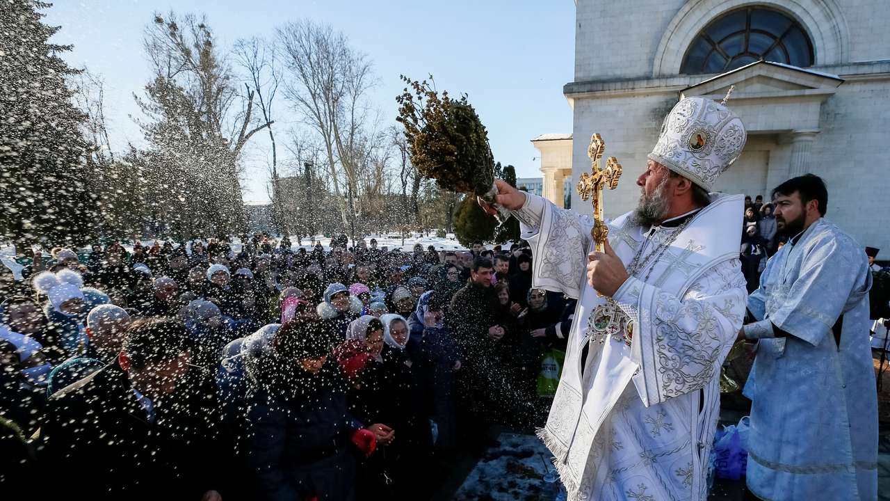 FILE PHOTO: Metropolitan of Chisinau and All Moldova Vladimir splashes water on believers during Orthodox Epiphany celebrations in Chisinau