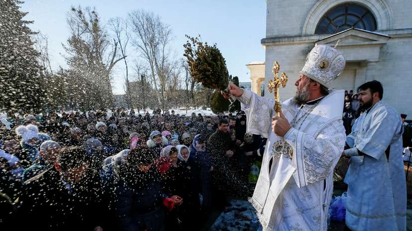 FILE PHOTO: Metropolitan of Chisinau and All Moldova Vladimir splashes water on believers during Orthodox Epiphany celebrations in Chisinau
