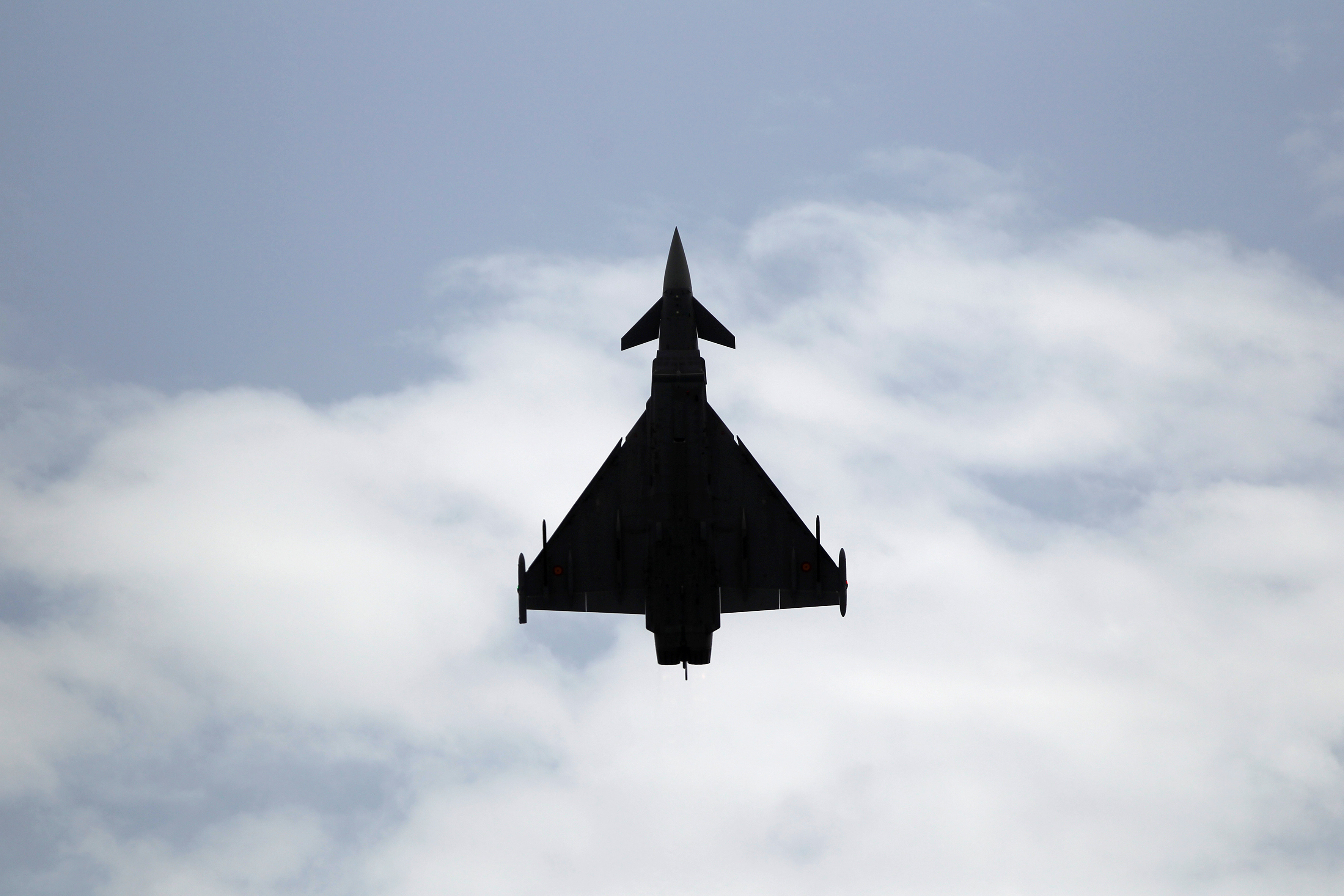 A Eurofighter Typhoon fighter jet flies vertically over a beach during an airshow in Torre del Mar