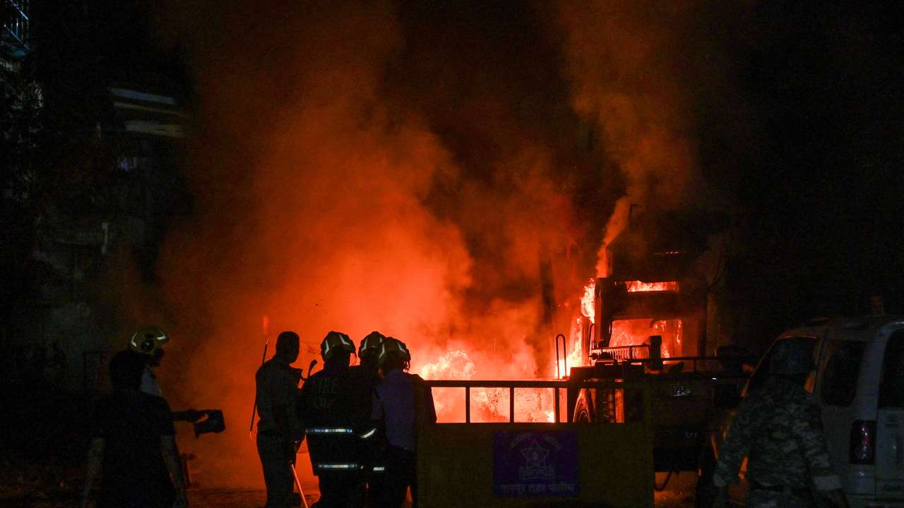 FILE PHOTO: Members of police stand as vehicles burn after clashes erupted due to demands over removal of the tomb of Mughal emperor Aurangzeb, in Nagpur