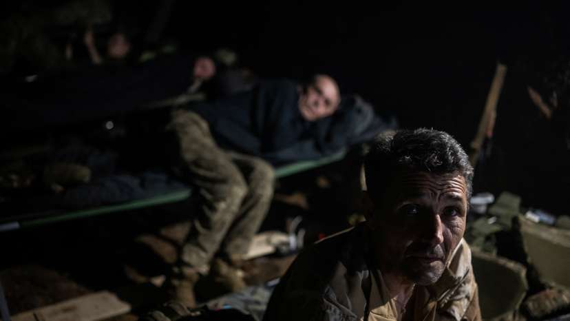 Servicemen rest inside a dugout on the front line, near the town of Vovchansk