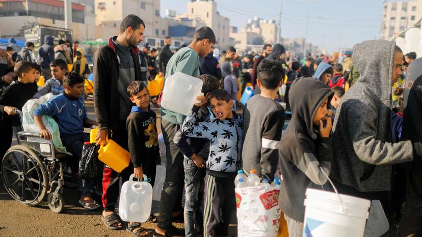 FILE PHOTO: Palestinians queue as they wait to collect drinking water, amid shortages of drinking water, as the conflict between Israel and Hamas continues, in Rafah