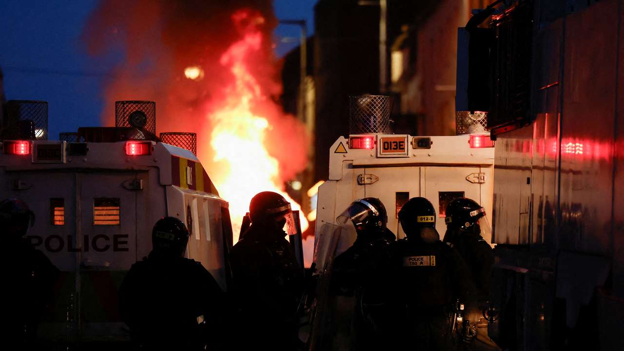 FILE PHOTO: Armed police in riot gear stand guard during a second night of riots, in Ballymena