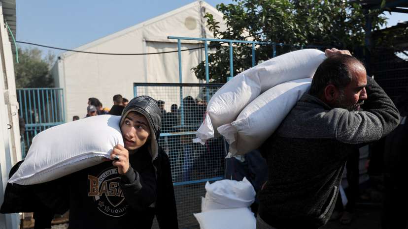 FILE PHOTO: Palestinians receive flour bags distributed by UNRWA during a temporary truce between Hamas and Israel, in Khan Younis