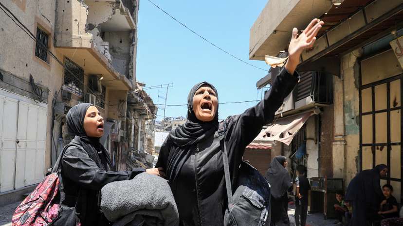 A Palestinian woman reacts in the aftermath of an Israeli strike on a house, in Gaza City