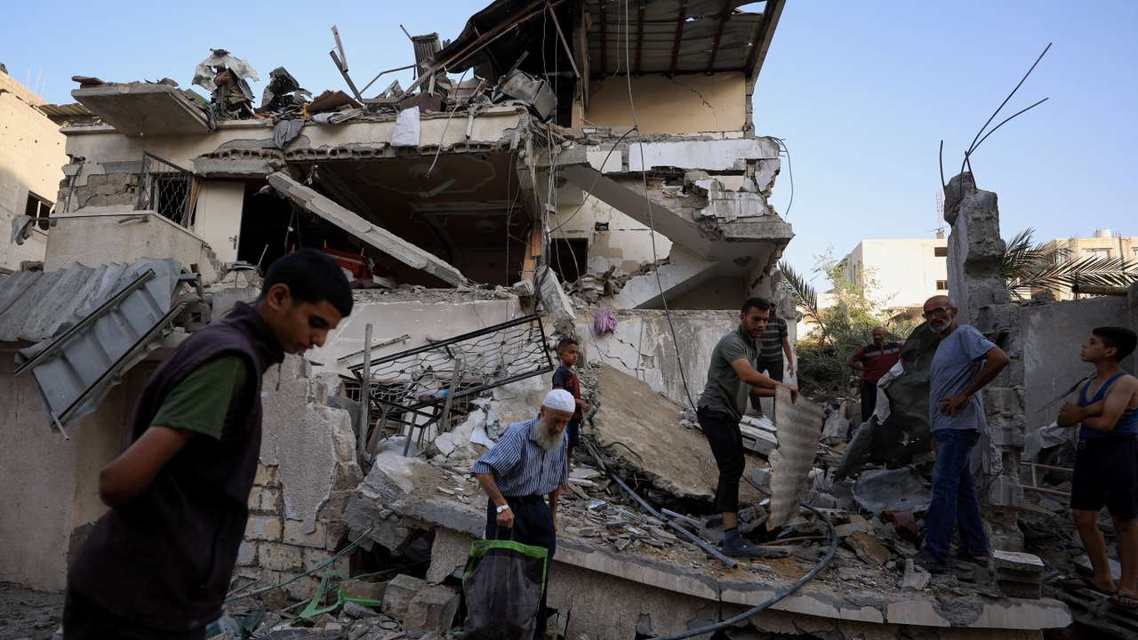 Palestinians inspect the site of an overnight Israeli strike on a house, in Gaza City