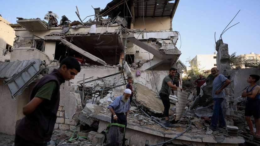 Palestinians inspect the site of an overnight Israeli strike on a house, in Gaza City