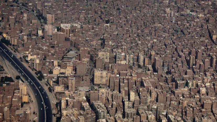 Buildings and houses are seen through the window of an airplane above Cairo
