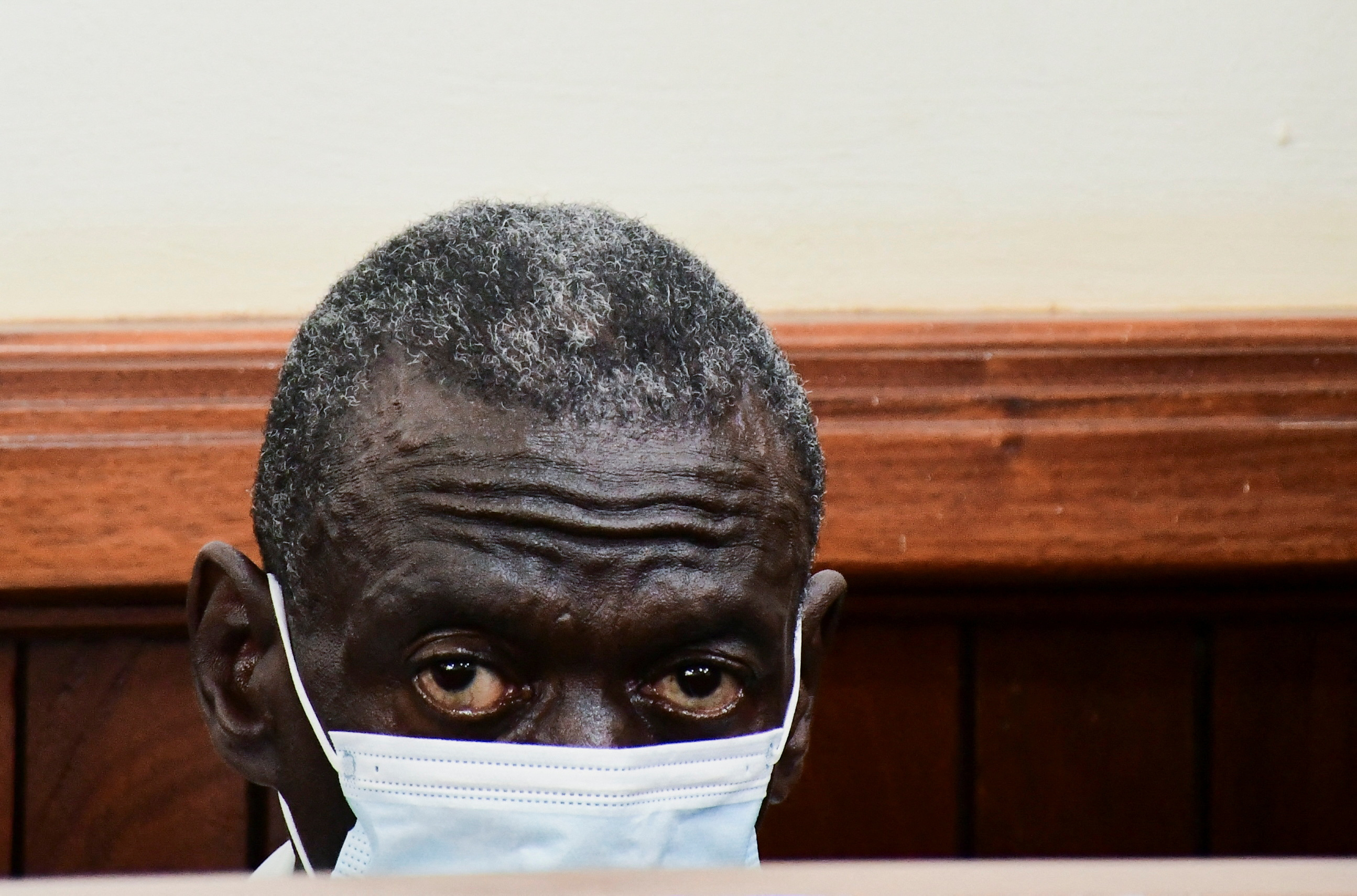 Uganda's four-time presidential candidate Kizza Besigye sits in the dock where he was charged with treason at the Chief Magistrate Court in Nakawa suburb of Kampala