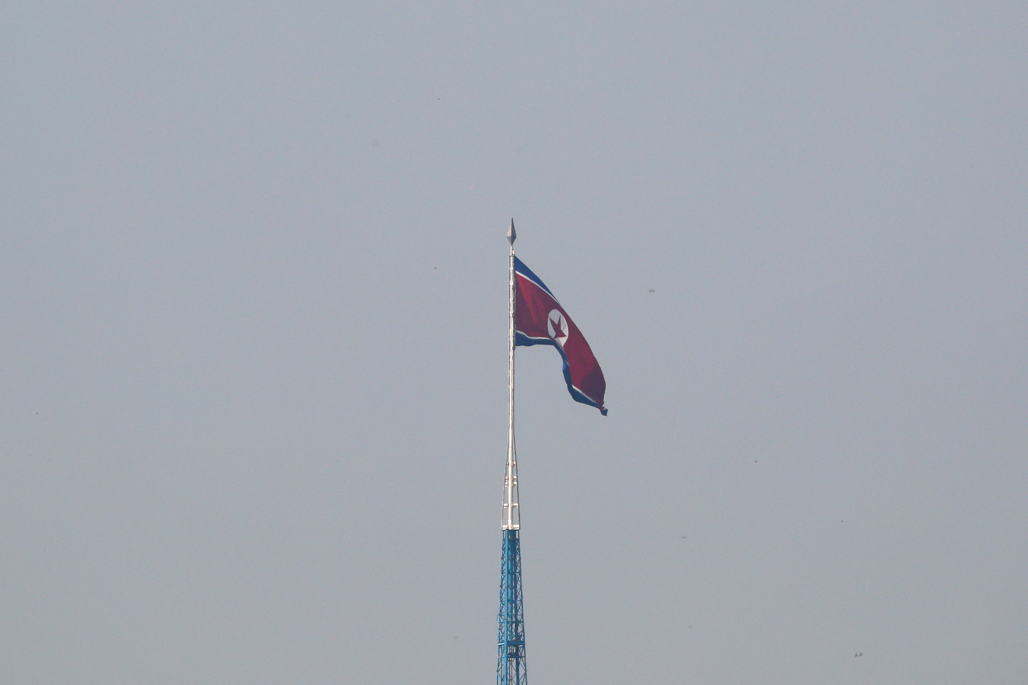 A North Korean flag flutters on top of a tower at North Korea's propaganda village of Gijungdong, as seen from Paju