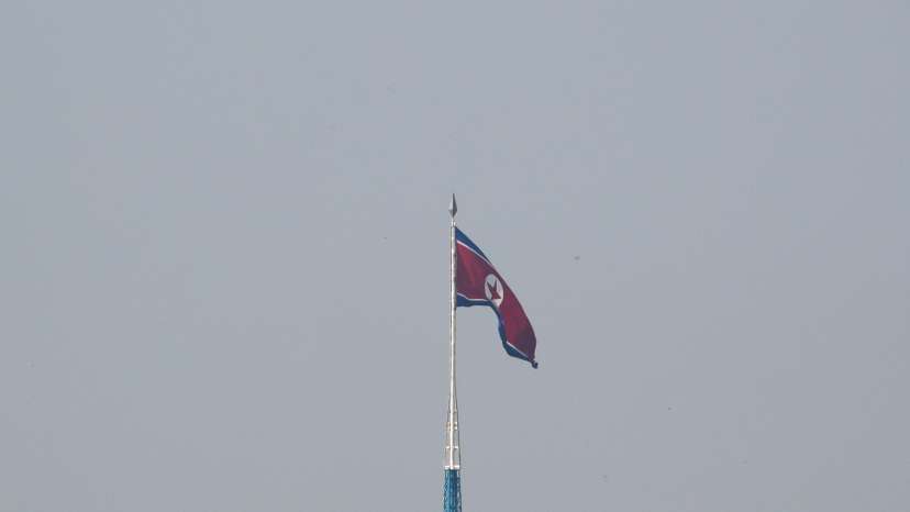 A North Korean flag flutters on top of a tower at North Korea's propaganda village of Gijungdong, as seen from Paju