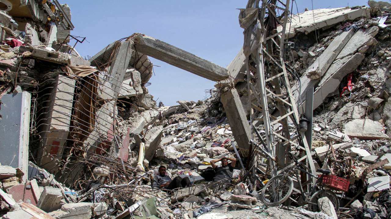 FILE PHOTO: Palestinians rest at the rubble of a residential building destroyed by Israeli strikes, amid the ongoing conflict between Israel and Hamas, in the northern Gaza Strip