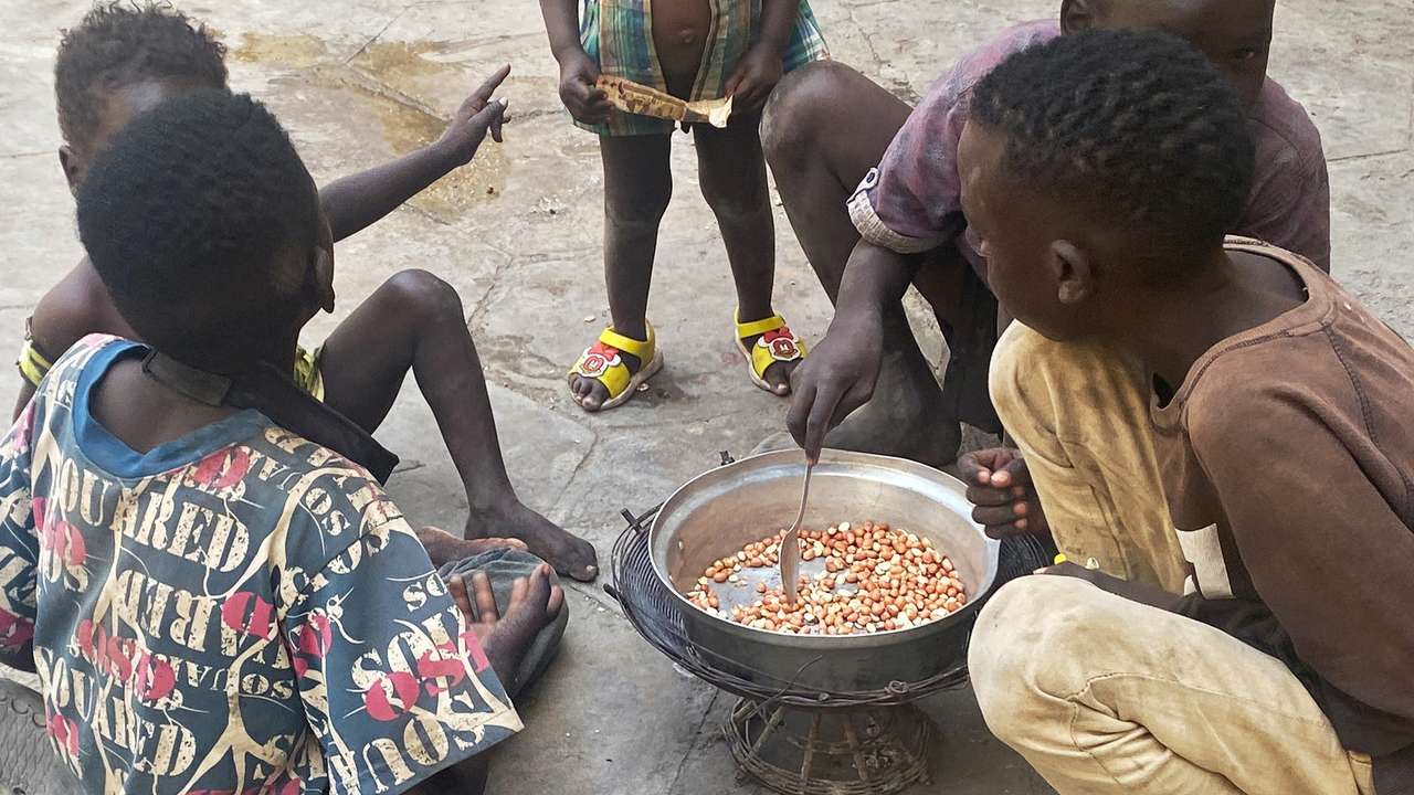 Children roast peanuts at a school in Port Sudan that has been converted into a center for displaced persons, amid a severe food crisis in Sudan