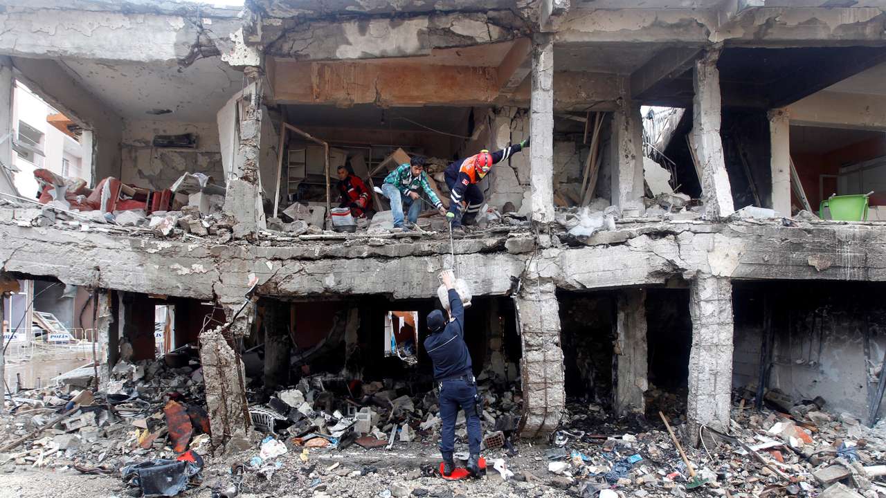 Search and rescue officers work at a damaged building at the site of blast in the town of Reyhanli