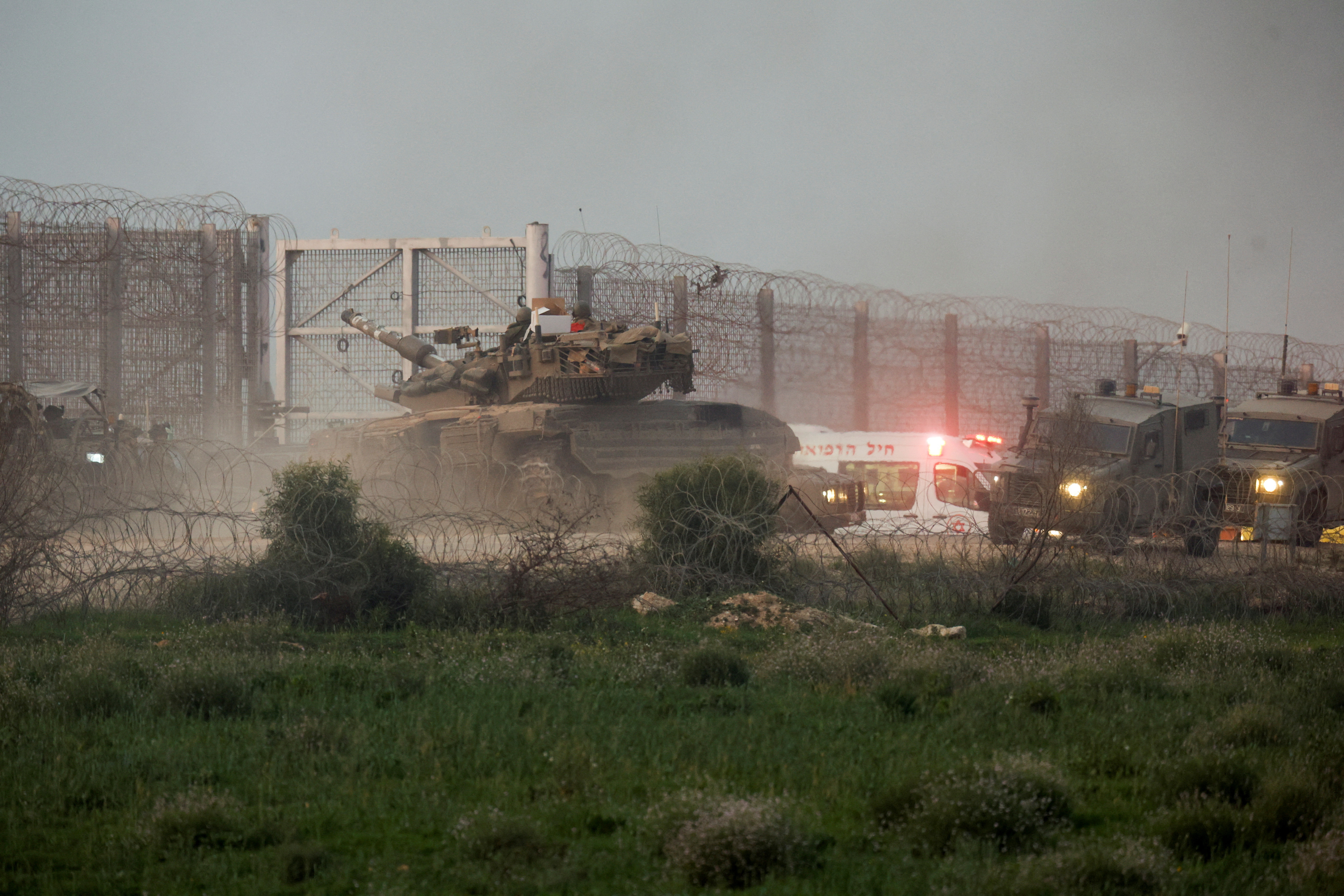 A tank manoeuvres along the Israel-Gaza border fence