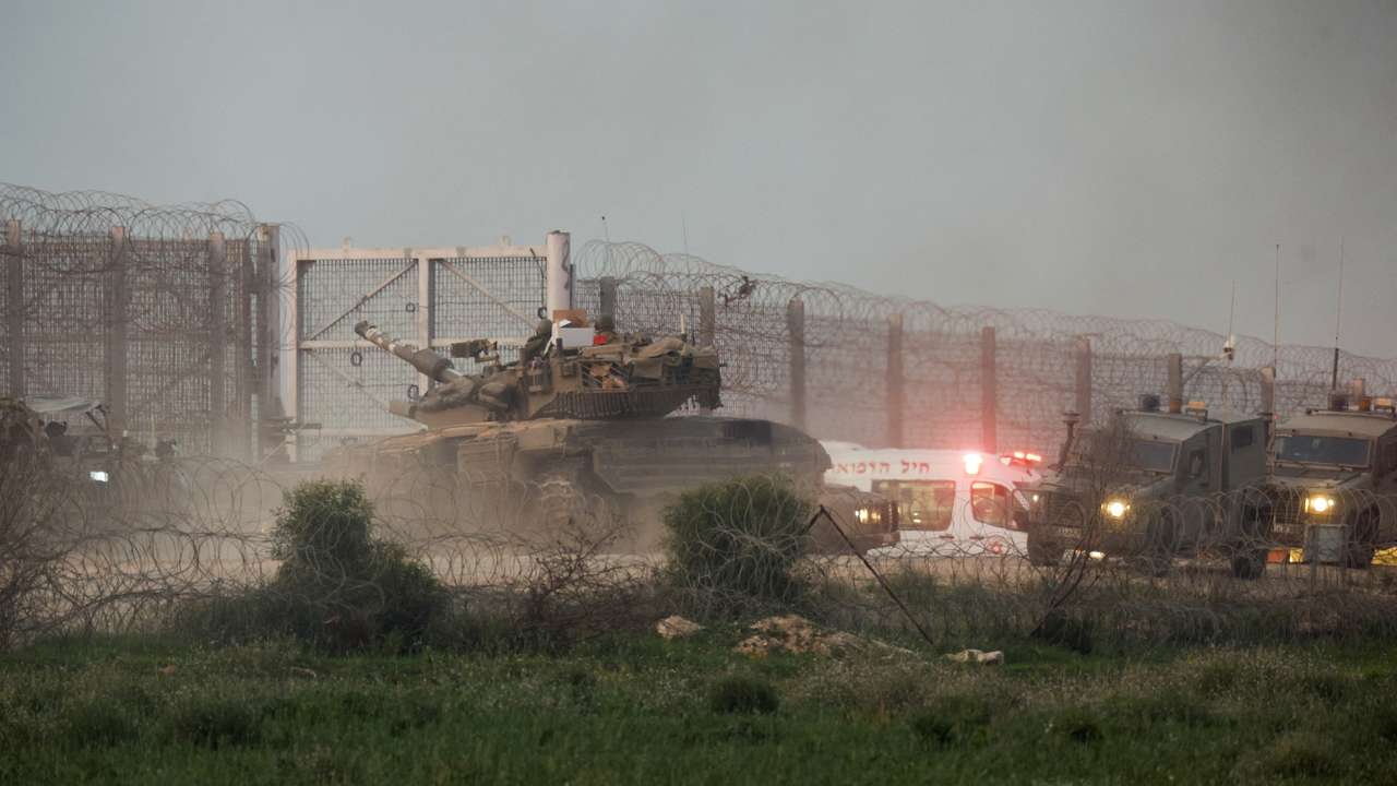A tank manoeuvres along the Israel-Gaza border fence