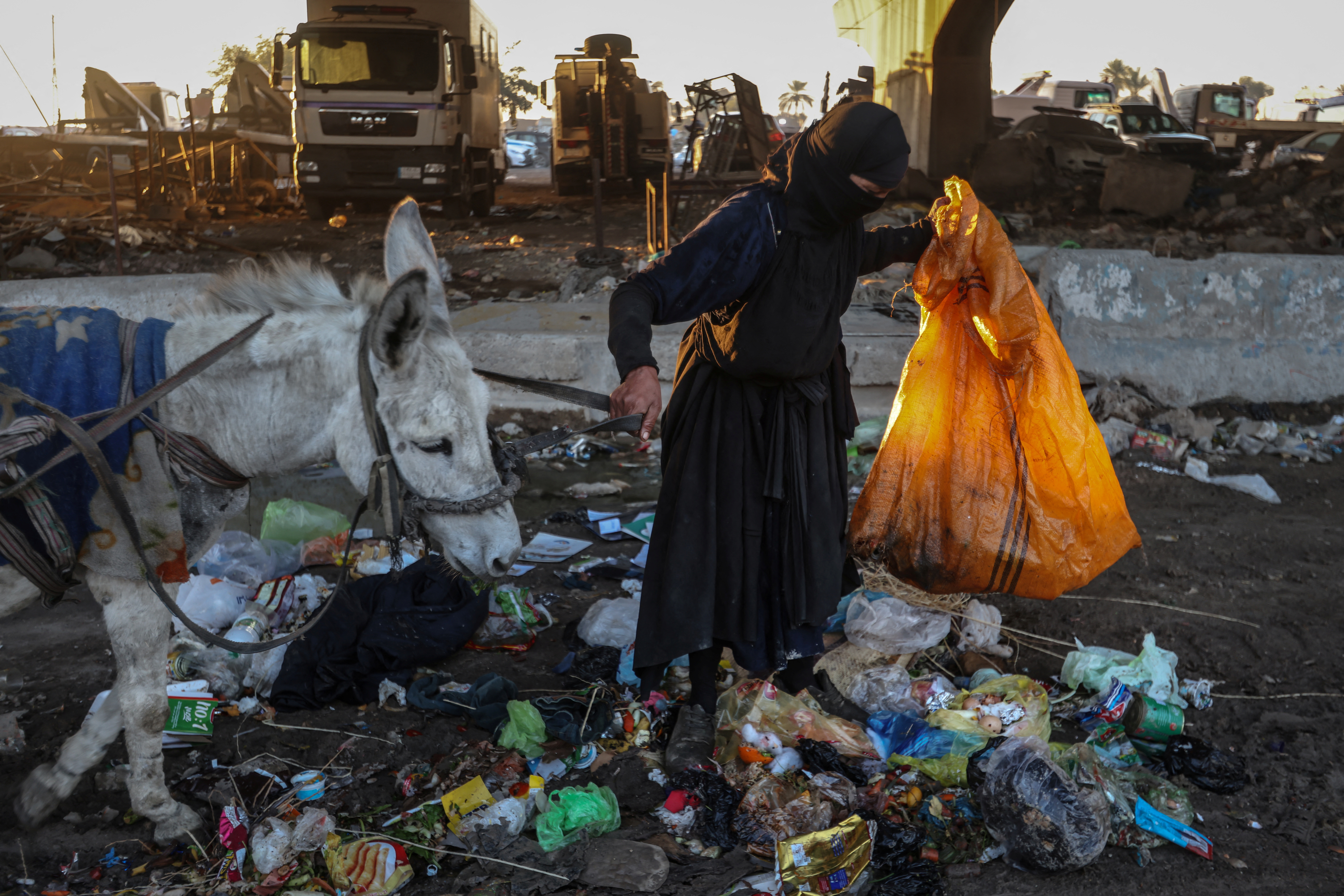 Picking through Baghdad's garbage for her family's Ramadan meal, faith keeps one woman going
