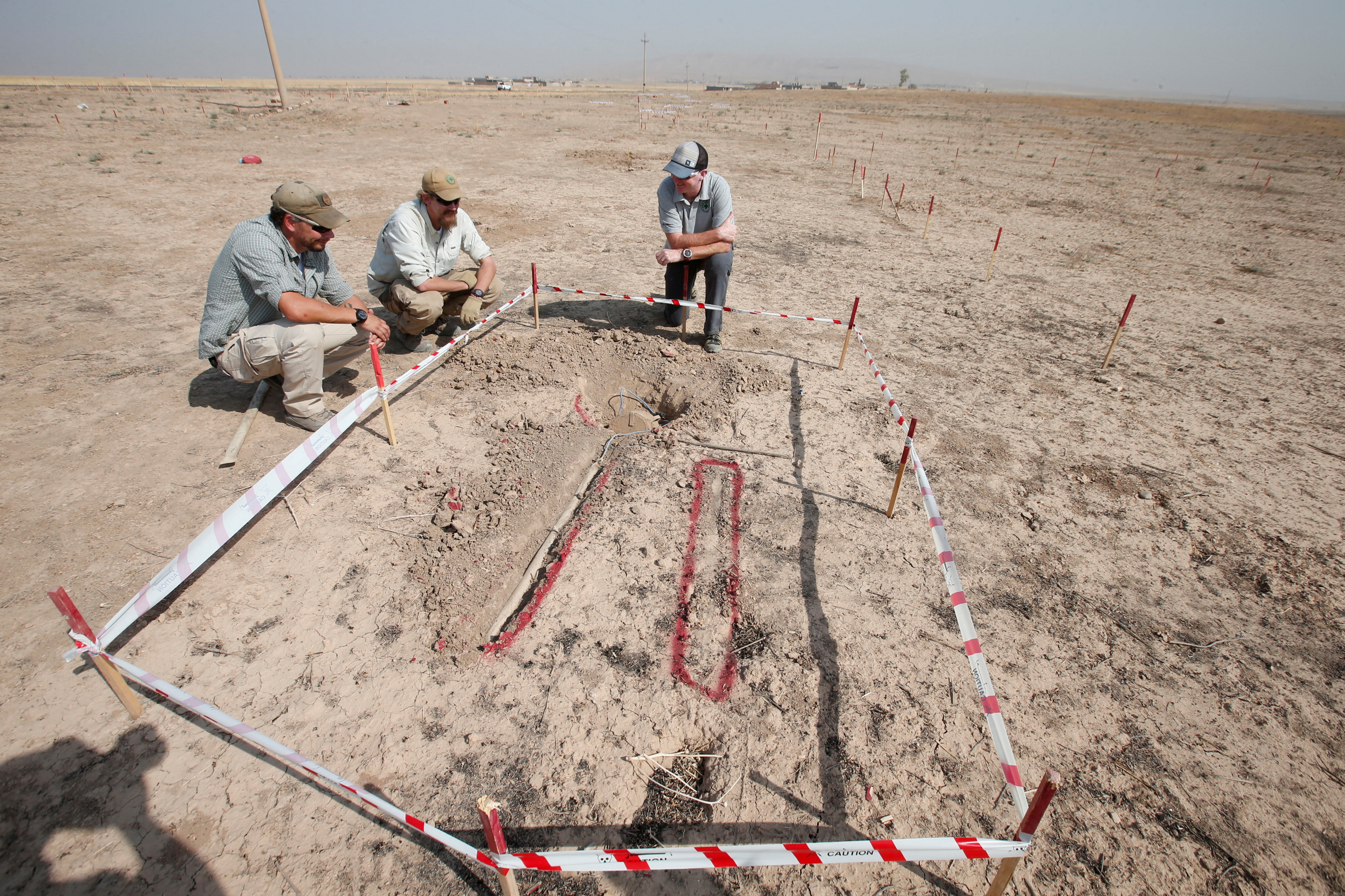 FILE PHOTO: Members of Norwegian People's Aid search for mines and explosive devices east of Mosul