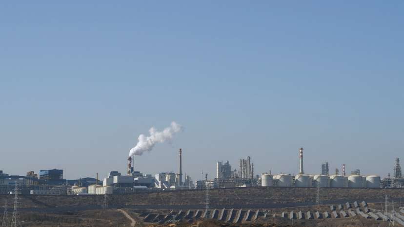 Solar panels lie in front of factories at Jinjie Industrial Park in Shenmu