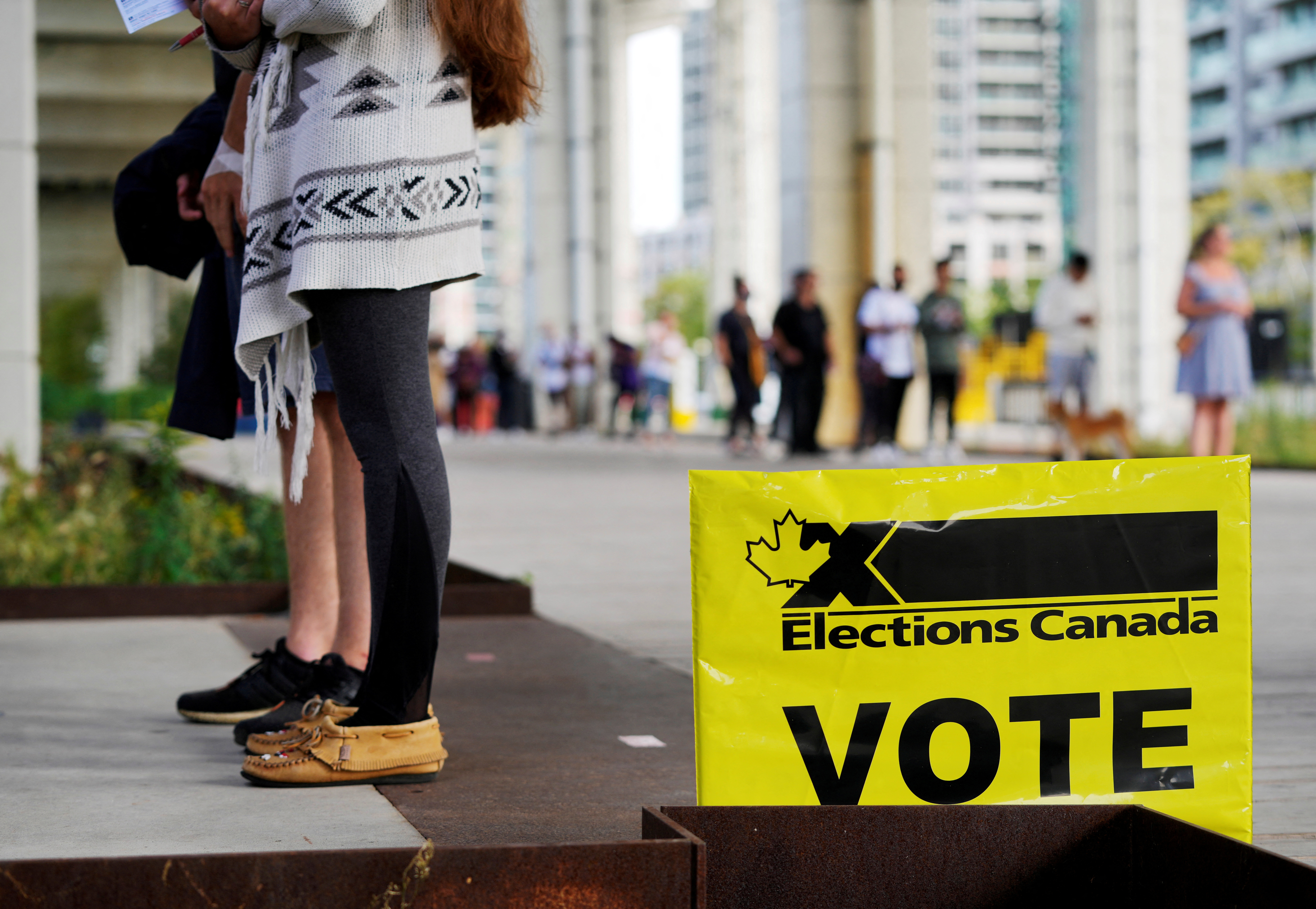 FILE PHOTO: People line up outside a polling station to vote in Toronto
