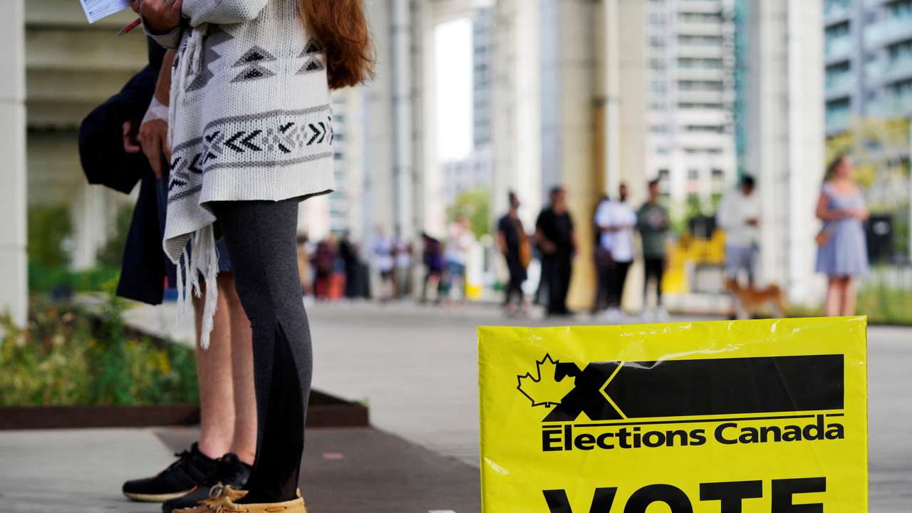 FILE PHOTO: People line up outside a polling station to vote in Toronto