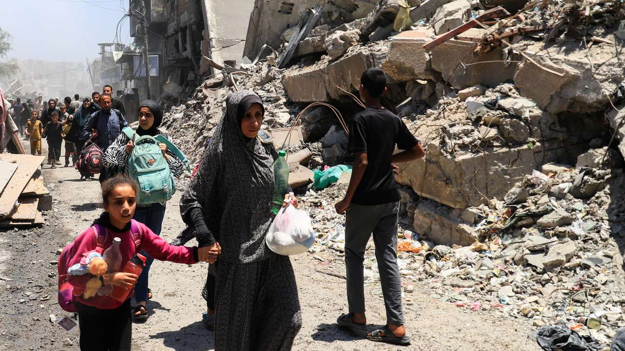 Palestinians evacuate in the aftermath of an Israeli strike on a house, in Gaza City