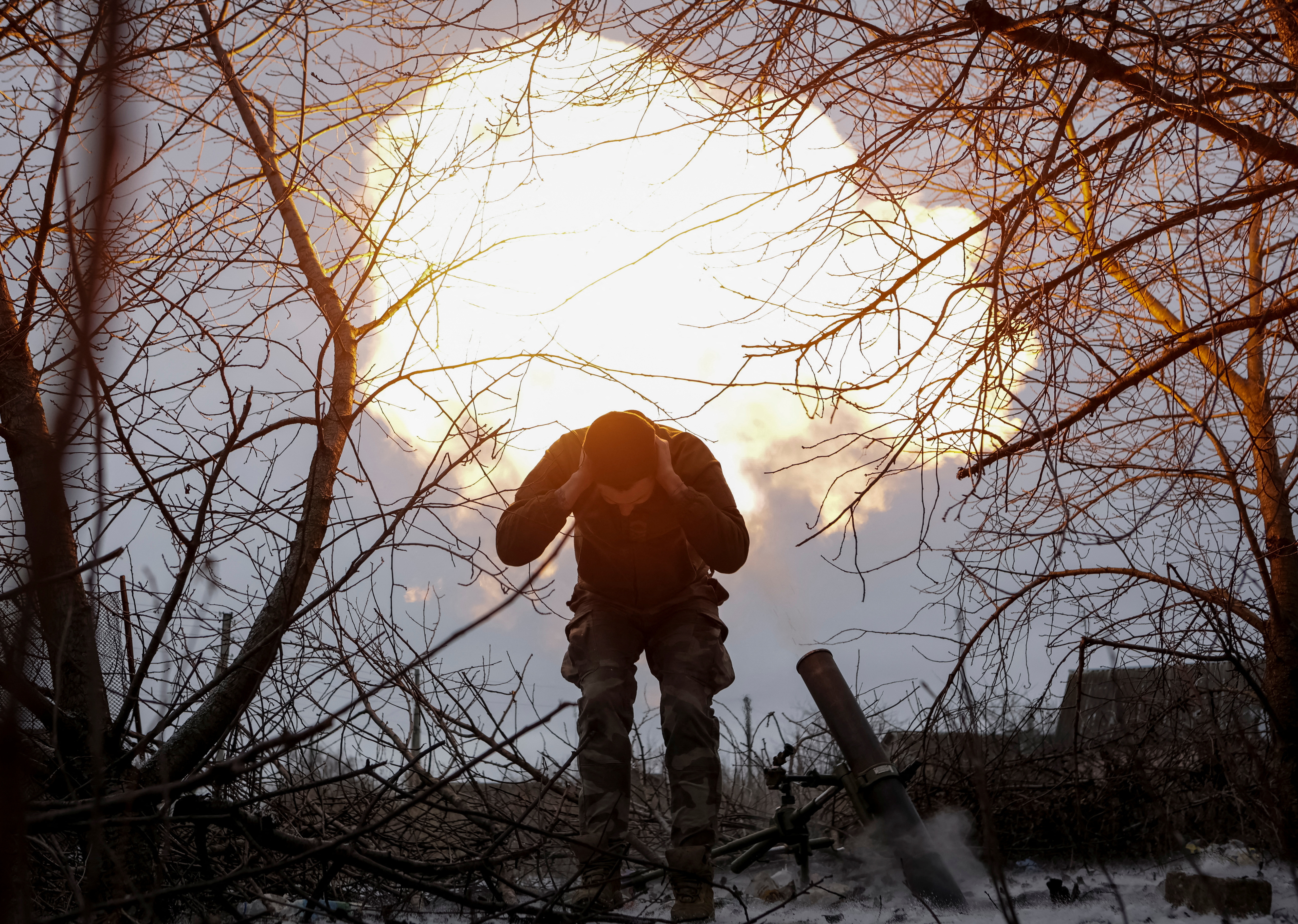 A Ukrainian serviceman fires a 120-mm mortar towards Russian troops at a frontline near the town of Vovchansk