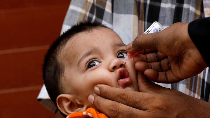 A girl receives polio vaccine drops, during an anti-polio campaign, in a low-income neighborhood, in Karachi