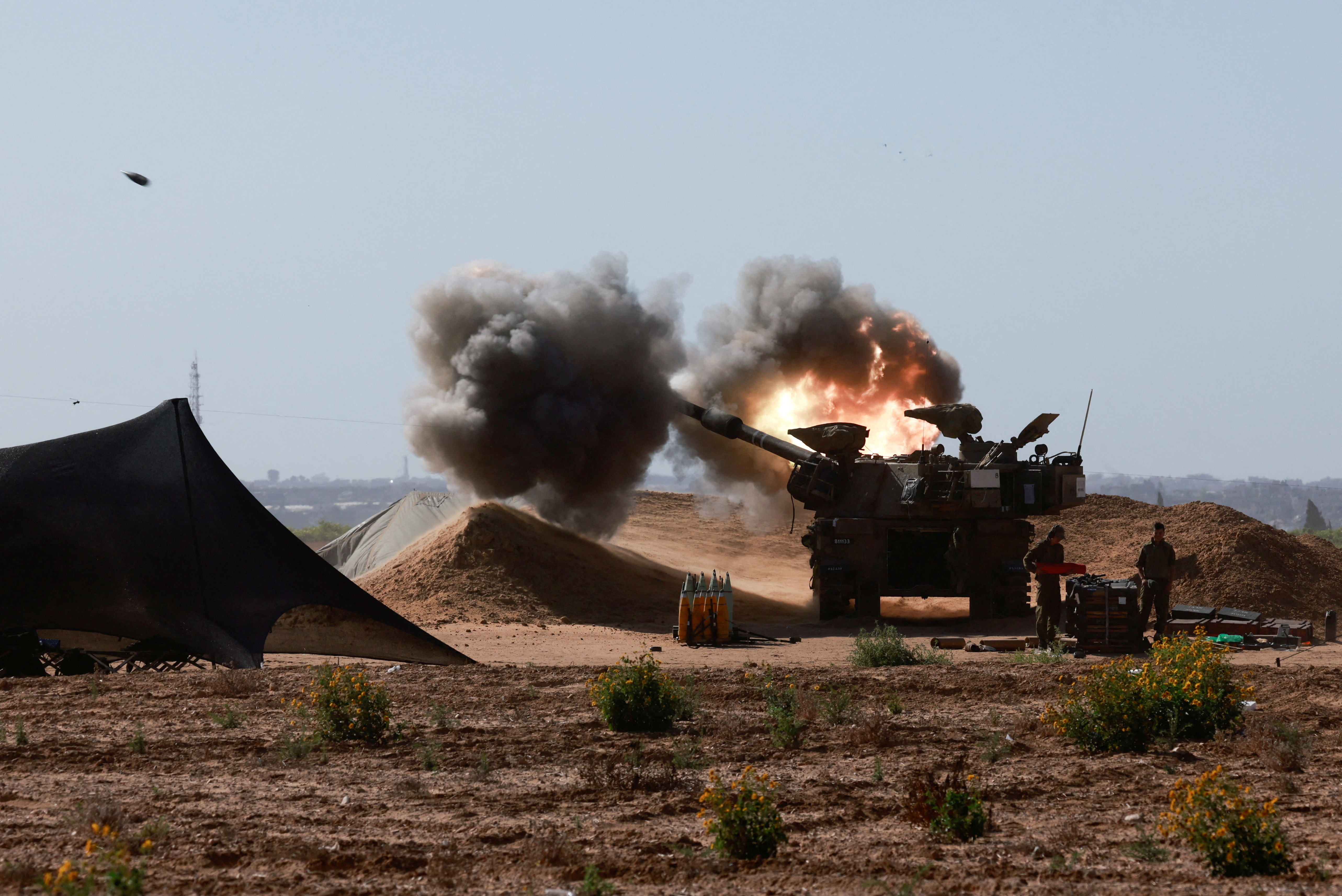 An Israeli military vehicle fires near the Israel-Gaza border, amid the ongoing conflict between Israel and the Palestinian Islamist group Hamas, in southern Israel