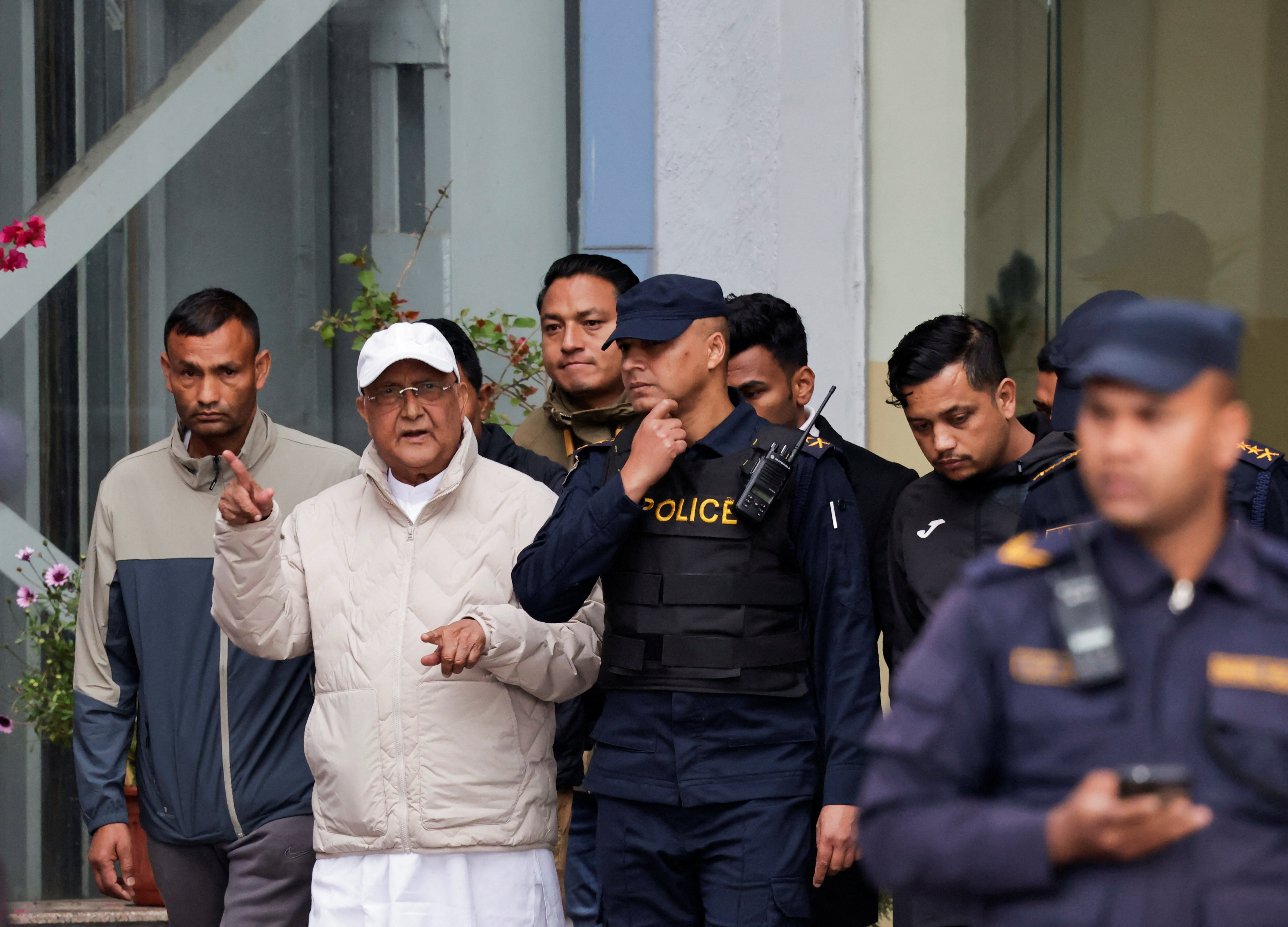 Former Nepal Prime Minister and Chairman of the Communist Party of Nepal, K.P. Sharma Oli gestures while being taken to a hospital from the District Police Range after his detention by police, in Kathmandu