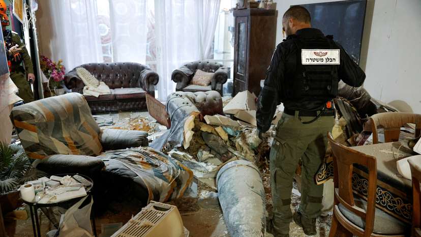 A member of the Israeli police inspects part of an Iranian missile in a living room, after Iran launched barrages of missiles towards Israel, amid the U.S.–Israeli conflict with Iran, in Rehovot