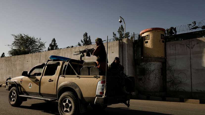 Taliban fighters patrol along a road in Kabul
