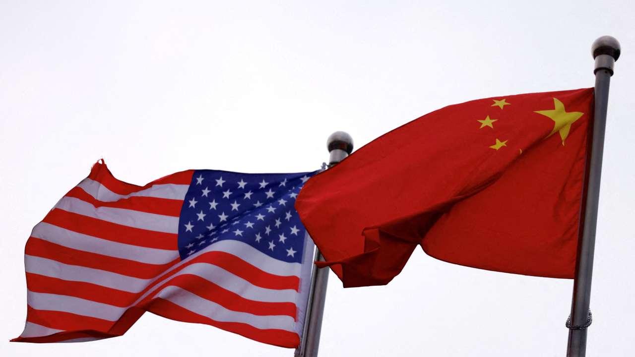 FILE PHOTO: Chinese and U.S. flags flutter outside the building of an American company in Beijing