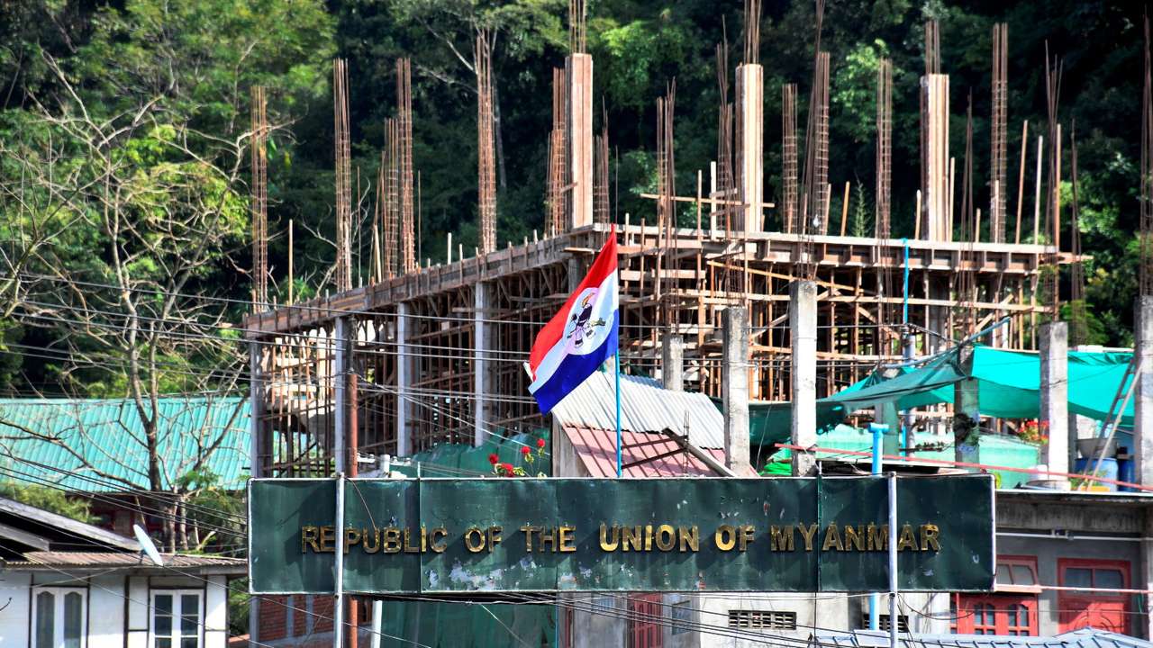 A flag of one of the Myanmar rebel forces is installed next to an under-construction structure in Myanmar's Khawmawi village on the India-Myanmar border as seen from Zokhawthar village