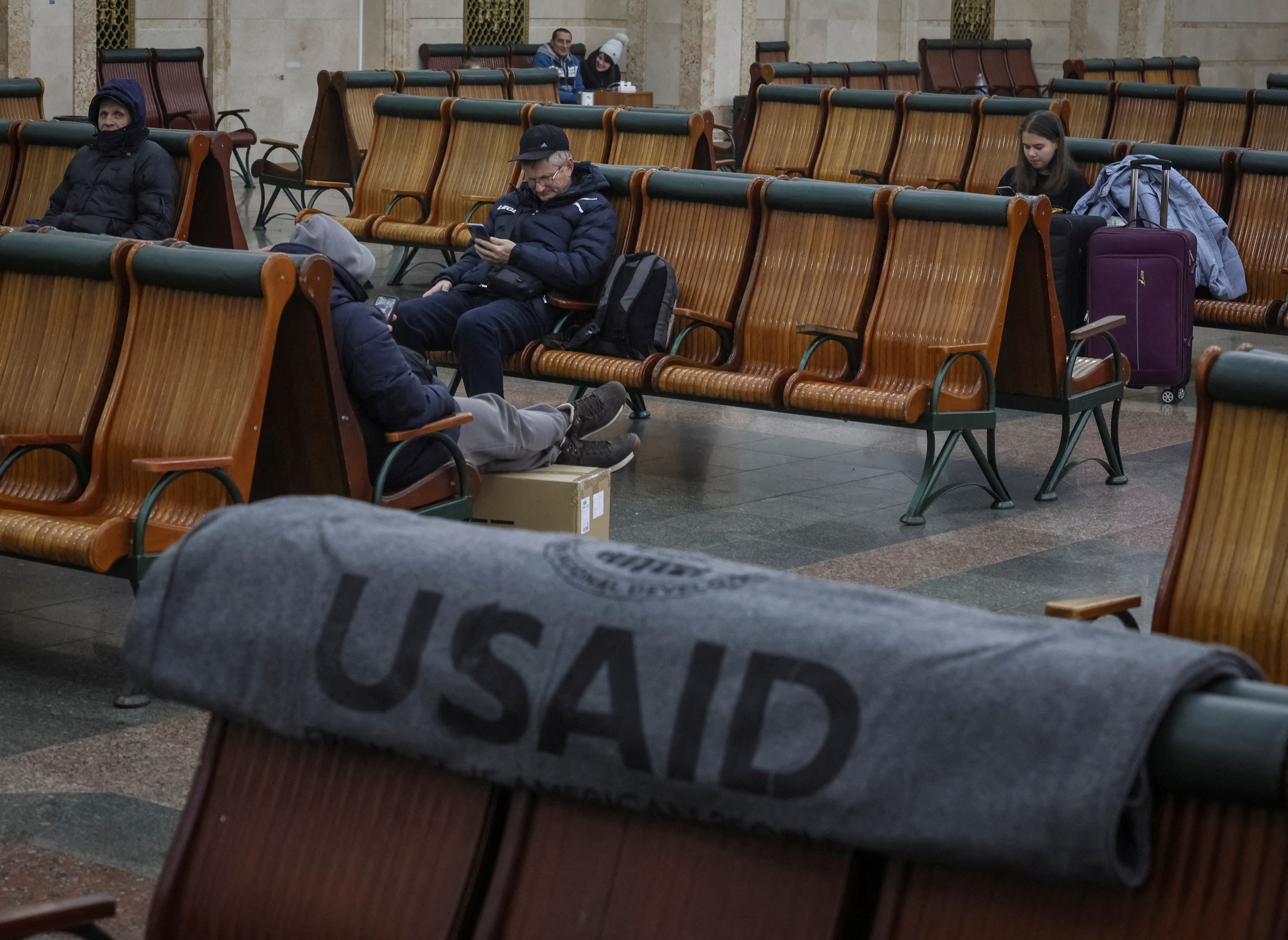 FILE PHOTO: Passengers rest in the waiting room as one of the blankets donated by the USAID is seen, in Kyiv