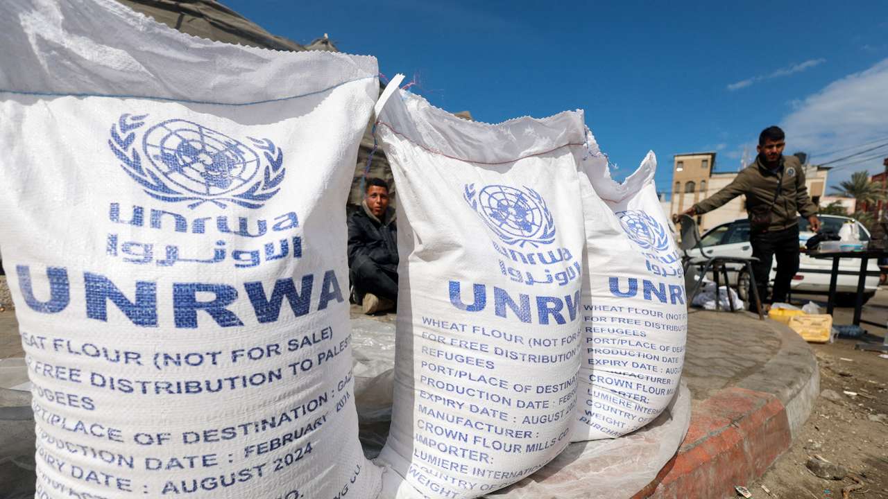 FILE PHOTO: Displaced Palestinians wait to receive United Nations Relief and Works Agency (UNRWA) aid, in Rafah