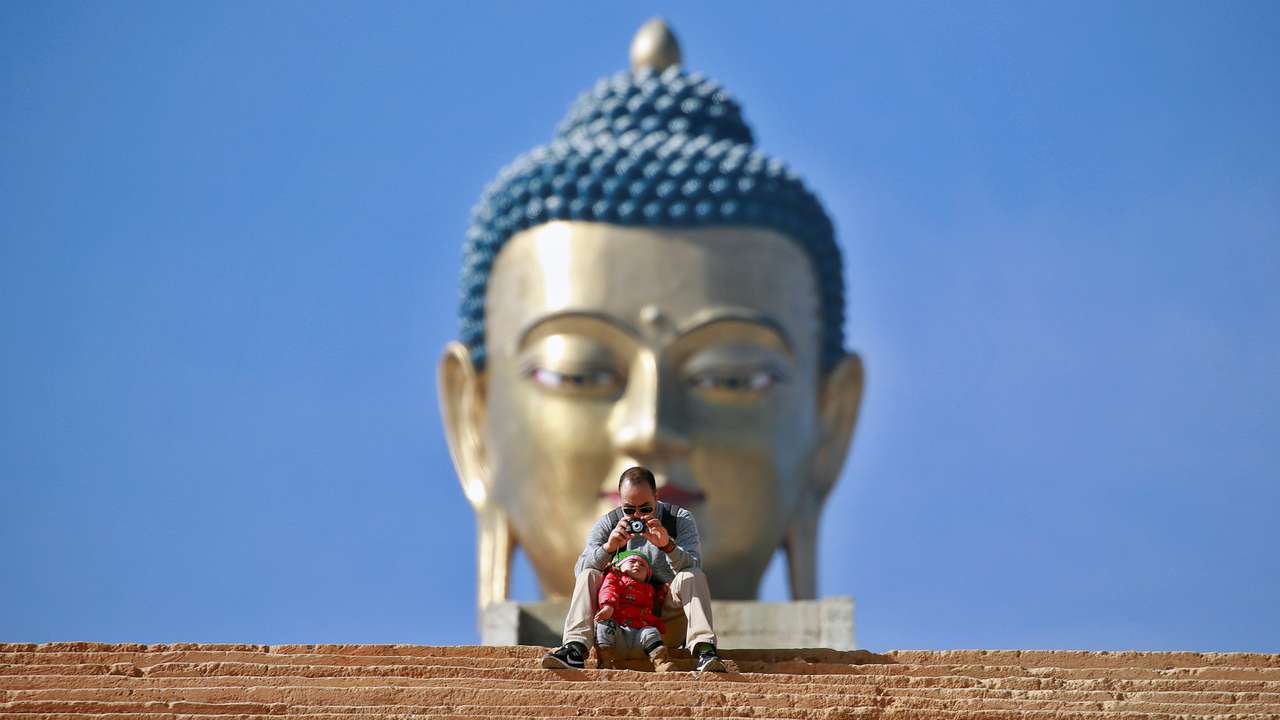 FILE PHOTO: A man takes a photograph in front of the Buddha Dordenma statue in Bhutan