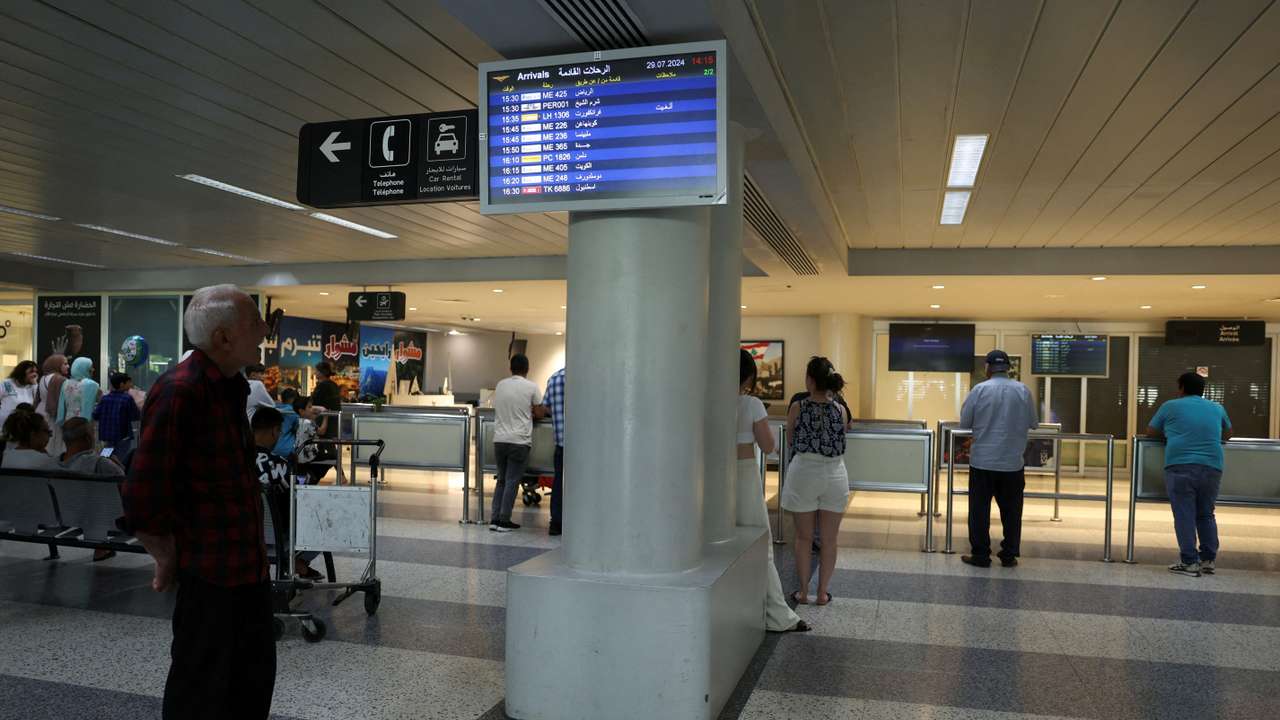 A man checks a flight information board showing a cancelled flight at the Beirut–Rafic Hariri International Airport, in Beirut