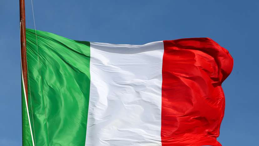 The Italian flag waves in front of The "Altare della Patria" also known as "Vittoriano" downtown Rome
