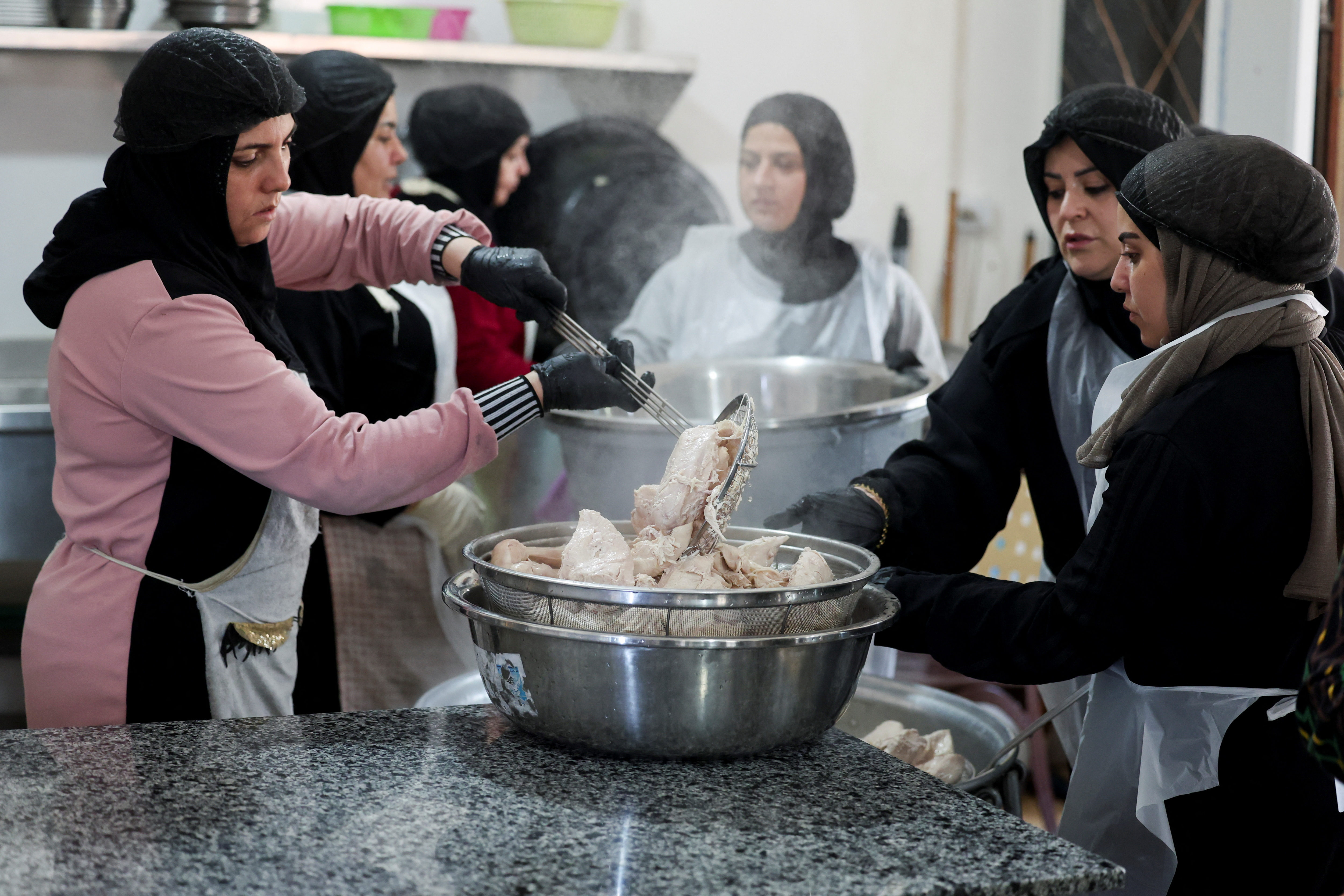 Women from Southern Lebanon prepare meals as they work in a community kitchen in Tyre