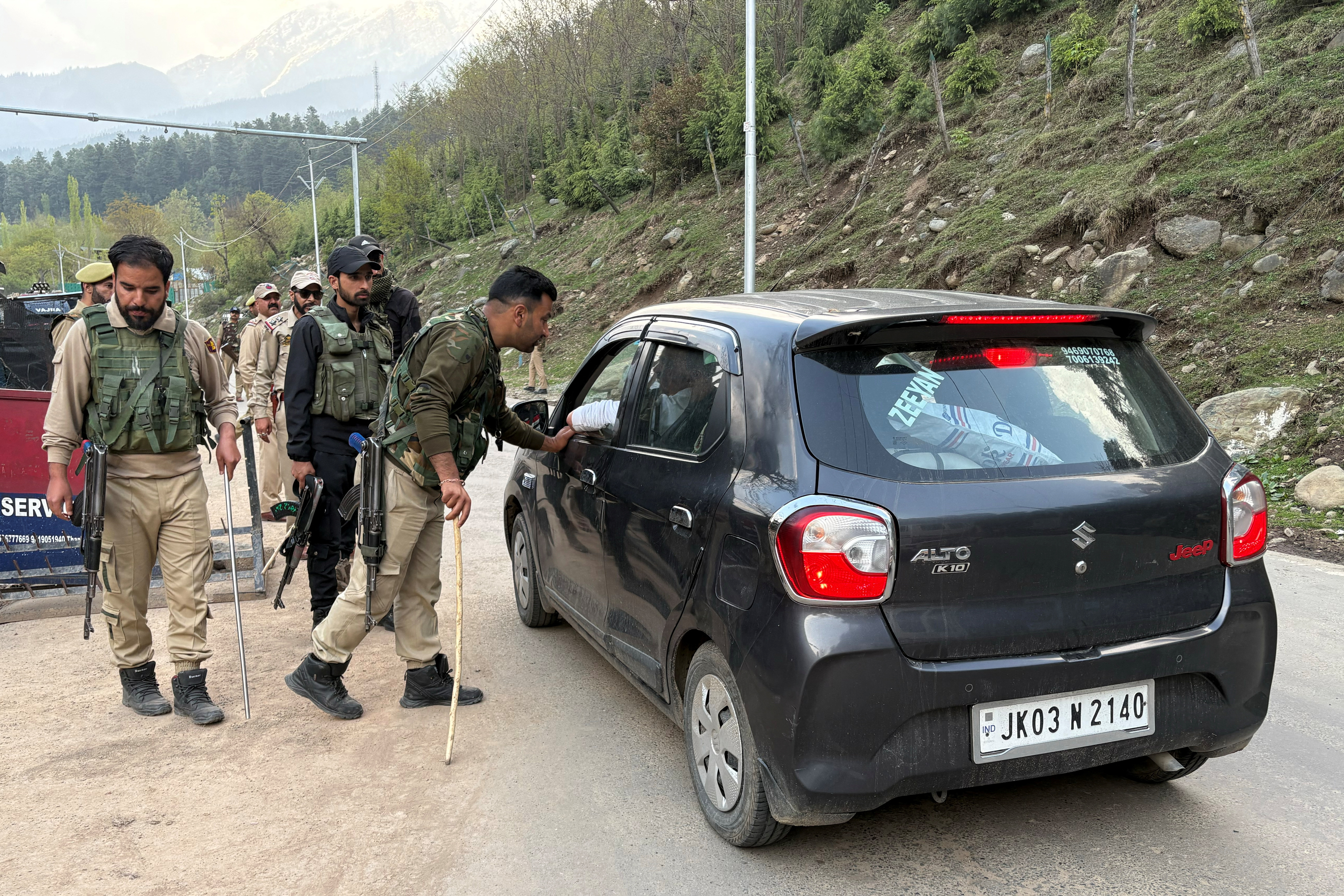 Indian police officers stop a vehicle at a check point following a suspected militant attack, near Pahalgam in south Kashmir's Anantnag district