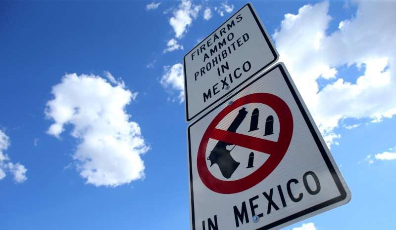 FILE PHOTO: A sign warns that firearms and ammunition are barred in Mexico