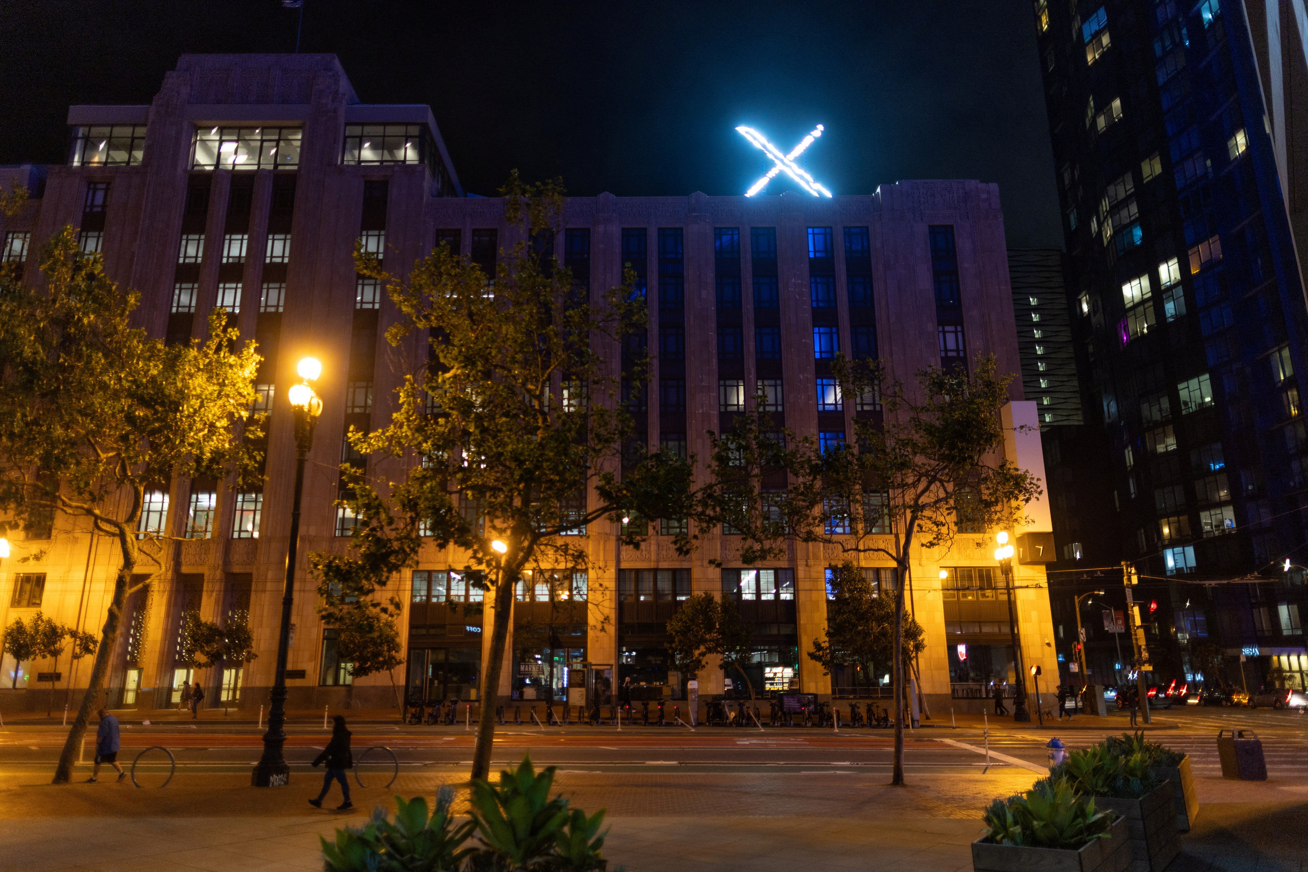 'X' logo is seen on the top of the messaging platform X, formerly known as Twitter
