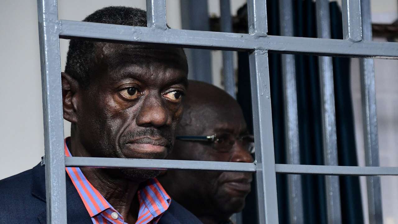 Ugandan four-time presidential aspirant Kizza Besigye stands in steel dock at Uganda Military General Court Martial in Kampala