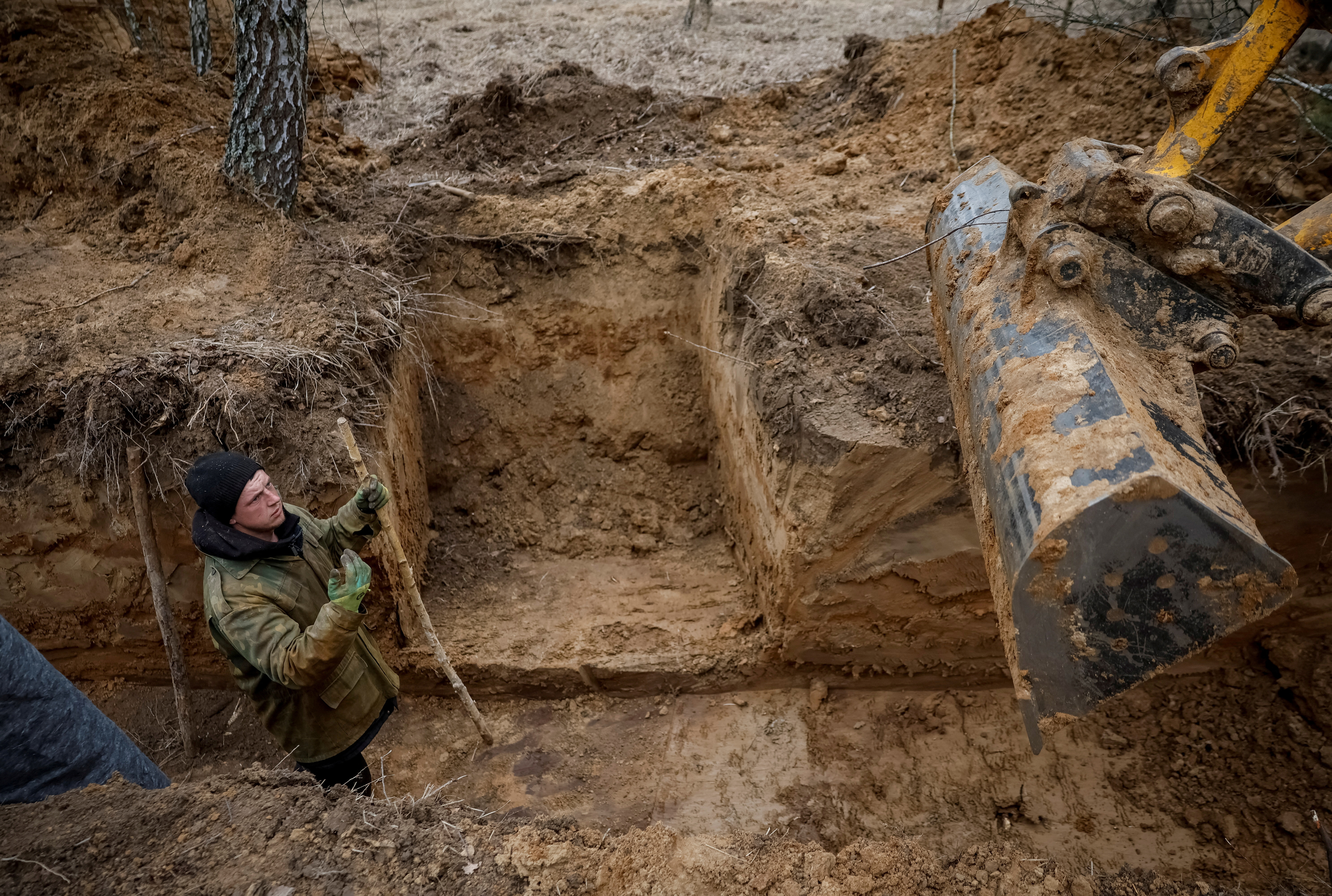 FILE PHOTO: A worker builds a trench as part of a system of new fortification lines near the Russian border in Chernihiv region