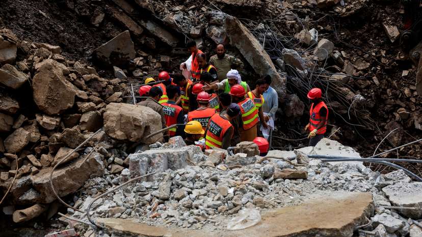 Rescue workers look for victims, following a storm that caused heavy rains and flooding in Dalori Bala village