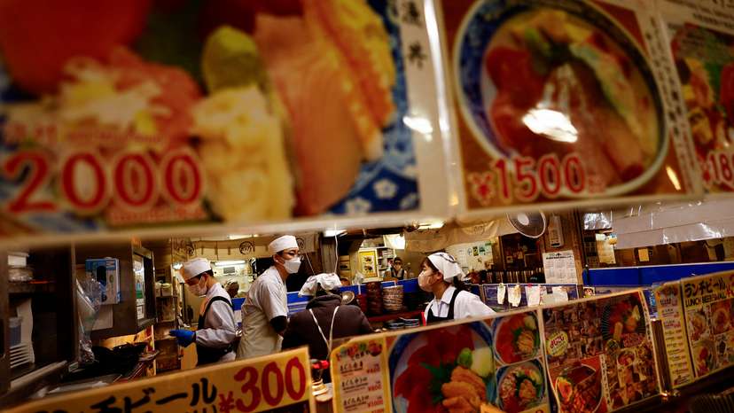 Employees of a seafood restaurant work in their kitchen space at Tsukiji Outer Market in Tokyo