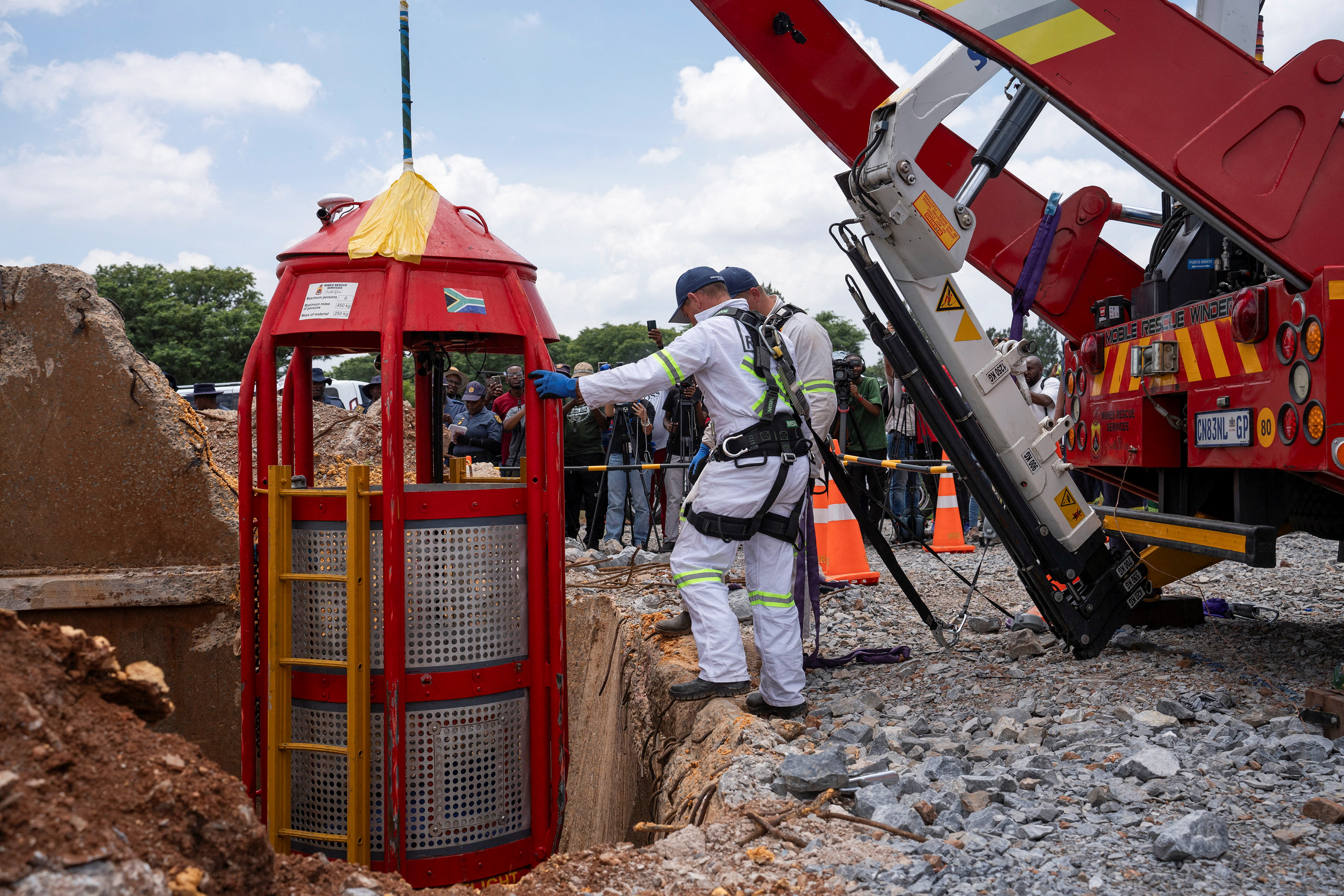Workers from Mines Rescue Services operate the mechanical cage that was used for rescue operations at the mine shaft in Stilfontein
