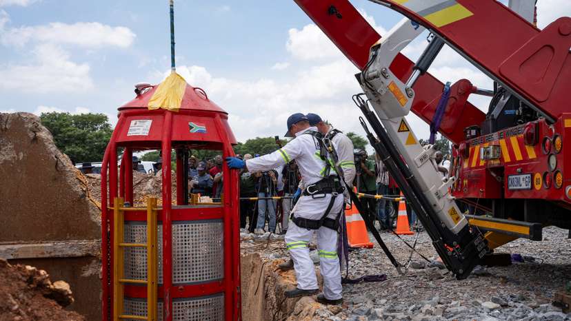 Workers from Mines Rescue Services operate the mechanical cage that was used for rescue operations at the mine shaft in Stilfontein