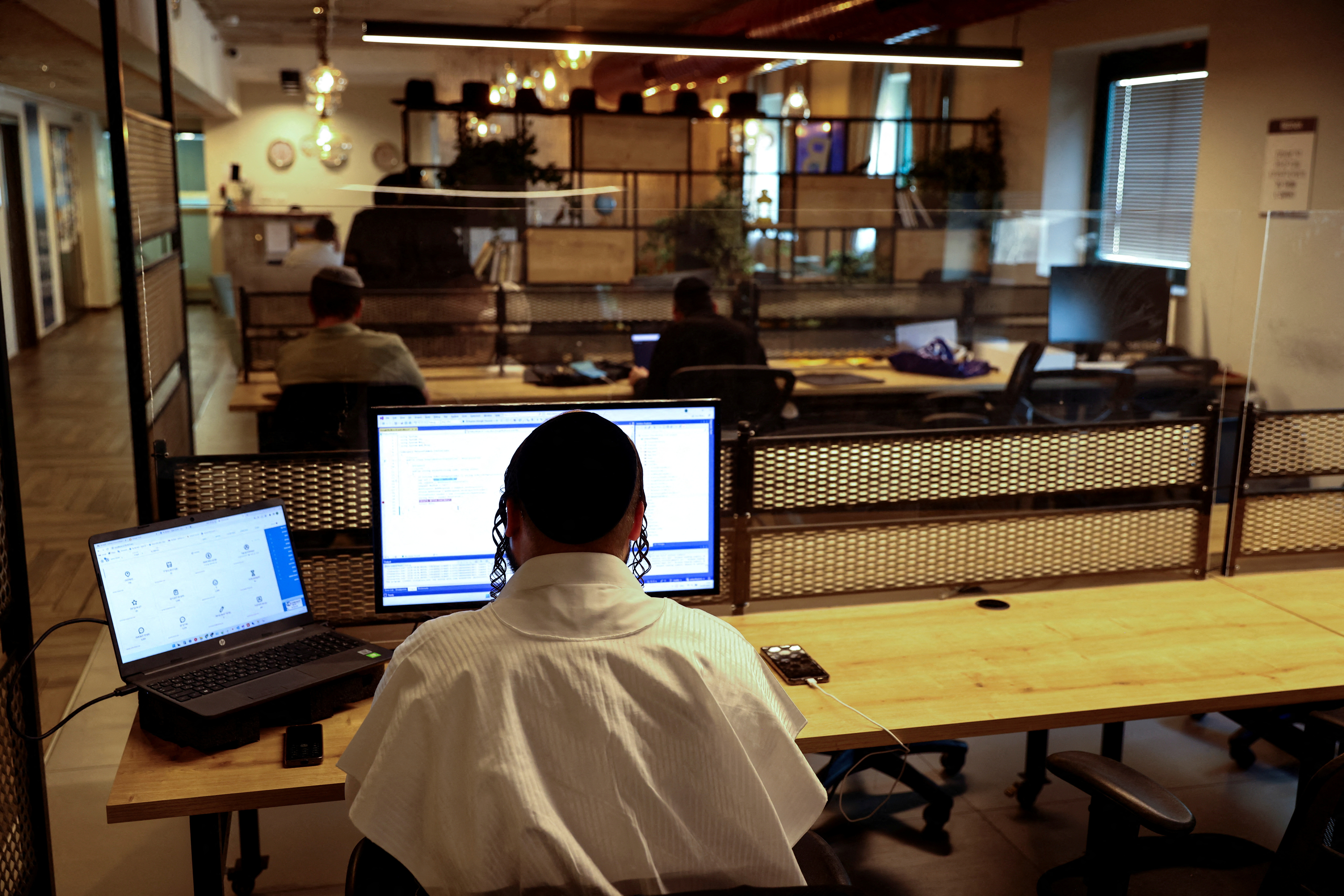 FILE PHOTO: Men work at the offices of a co-working space run by Bizmax, an innovation center for Ultra-Orthodox Jewish men in Jerusalem